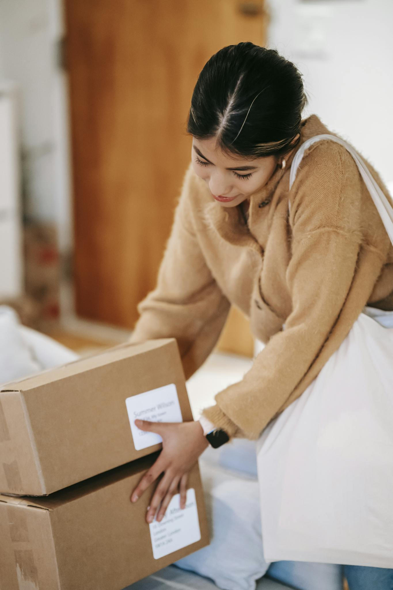 Female customer with shopping bag getting stack of carton boxes with delivered goods at home